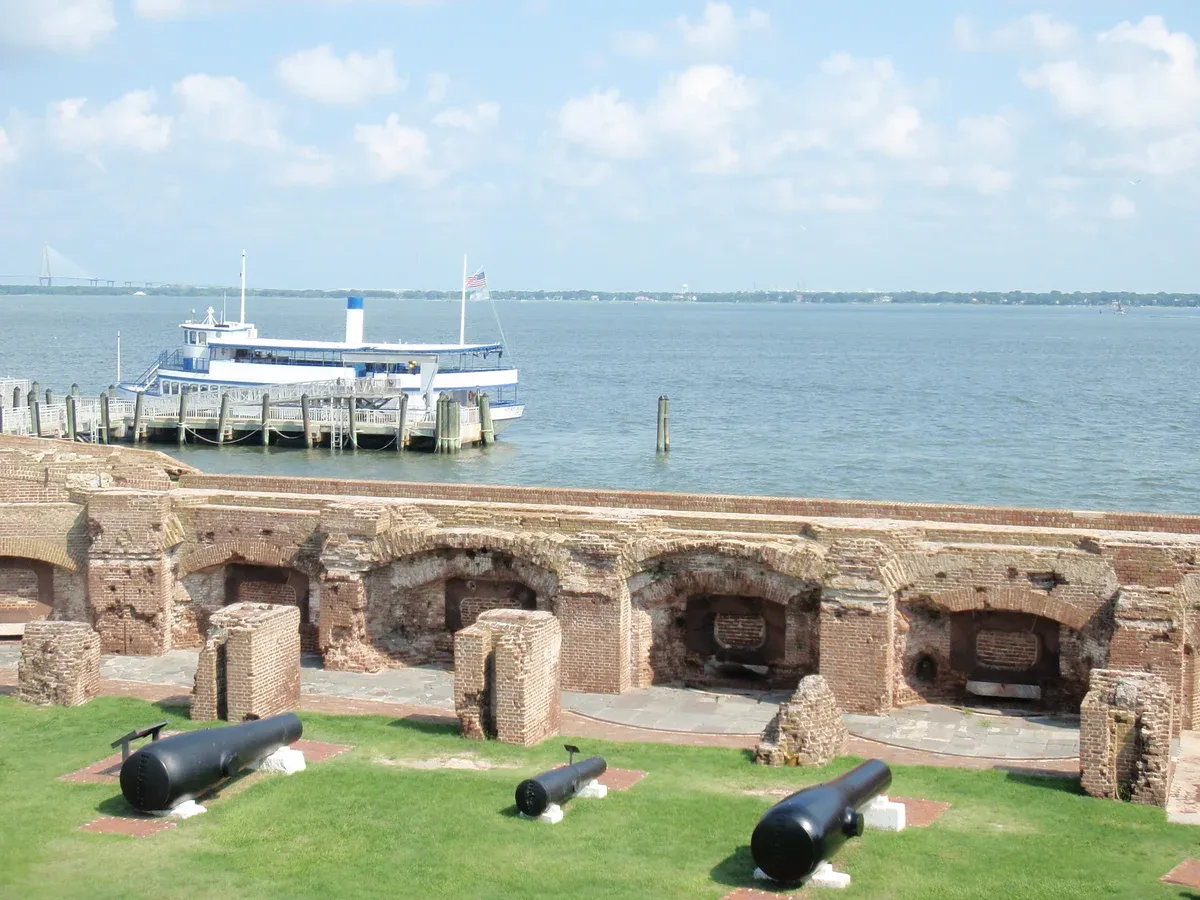 Fort Sumter casemates and cannons with a tour ferry at the dock in Charleston Harbor, a stop on Charleston boat tours